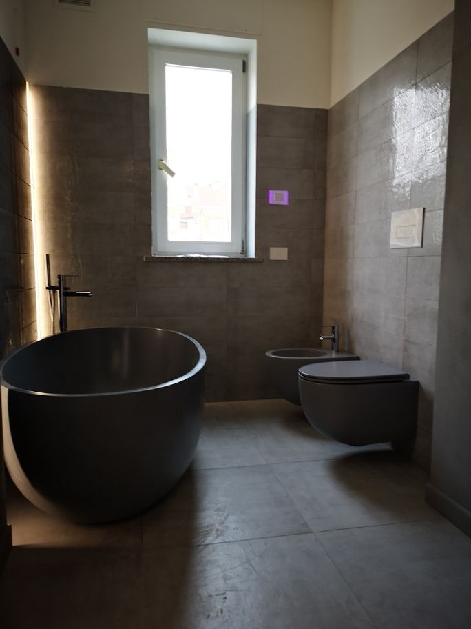 Bagno con vasca freestanding e giochi di luce realizzato da Gilardi Interiors on Staging, Progettazione di interni a Melzo